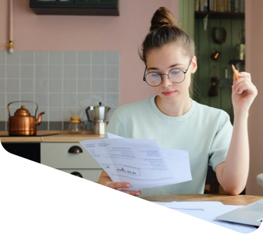 Nebenkostenabrechnung für die Wohnung. Junge Frau sitzt an ihrem Küchentisch und liest ihre Nebenkostenabrechnung